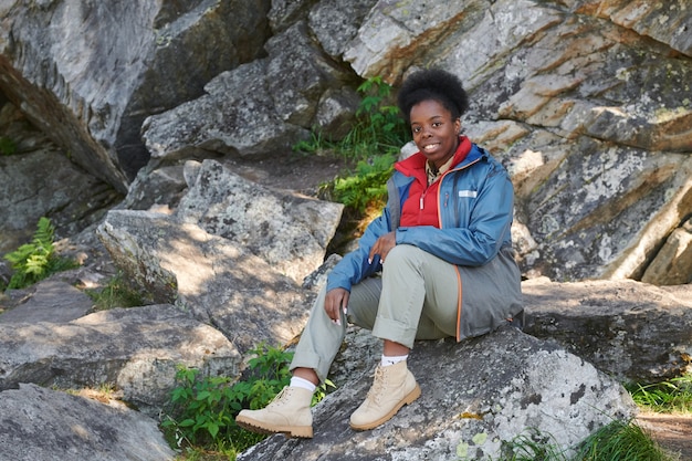 Portrait of African woman sitting on rocks and  during hiking