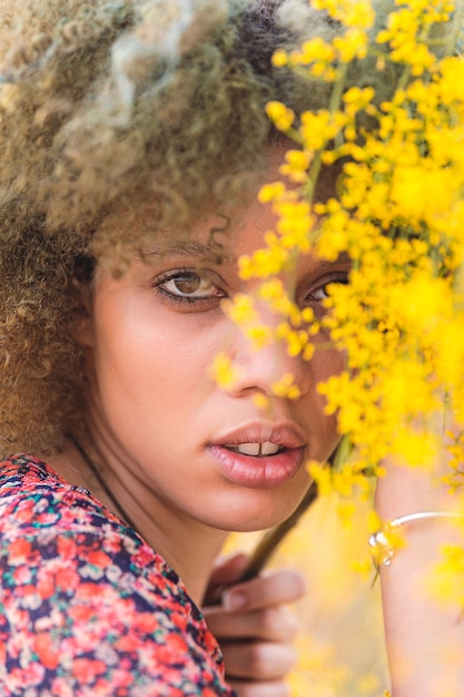 Portrait of an afro woman whit yellow flowers