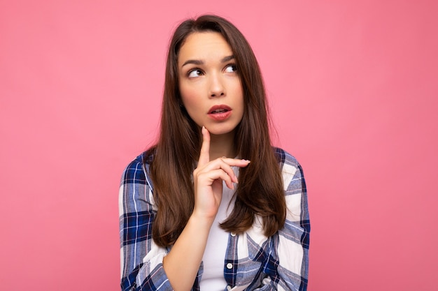 Portrait of amazing thoughtful beautiful young woman deep thinking creative female person holding arm on chin wearing stylish outfit isolated on colorful background with copy space.