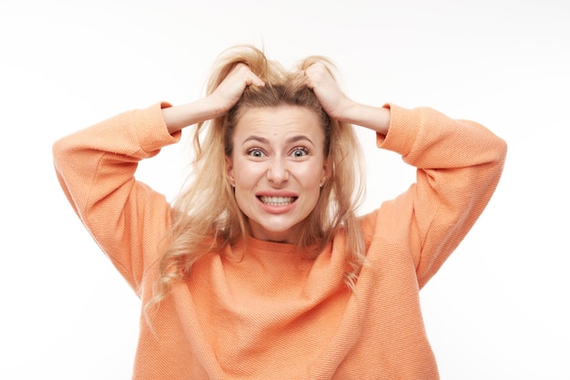 Portrait angry blonde young woman screaming isolated on white studio background showing negative emotions