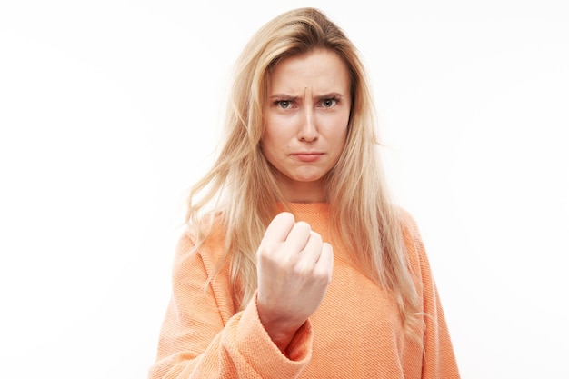 Portrait angry blonde young woman screaming isolated on white studio background showing negative emotions