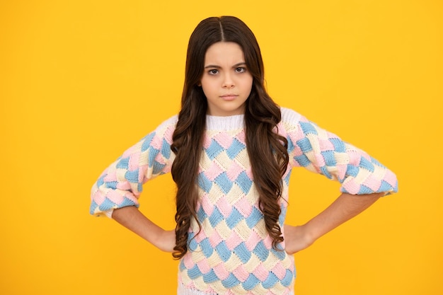 Portrait of angry teen girl looking at camera isolated on studio background Unhappy upset teenager child