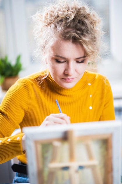 Portrait of an artist girl who creates a painting at home