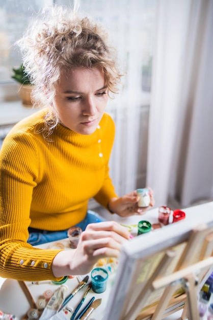 Portrait of an artist girl who creates a painting at home