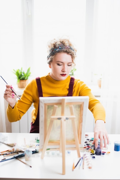 Portrait of an artist girl who creates a painting at home