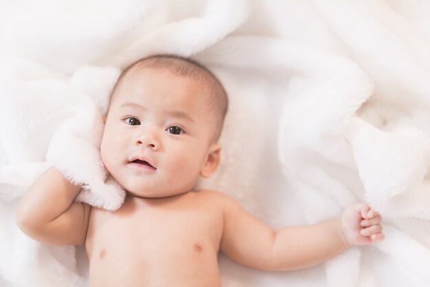 Portrait asia baby on white bed