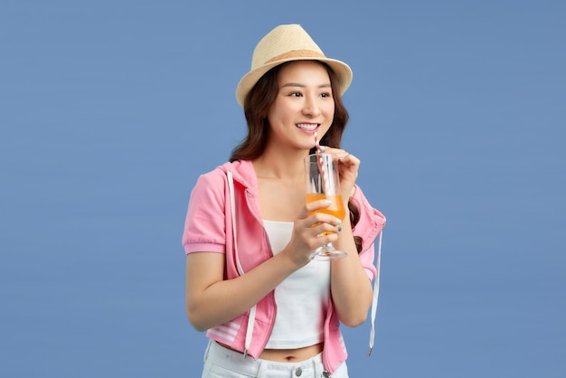 Portrait Asian beautiful happy young woman smiling cheerful and holding a glass of orange juice