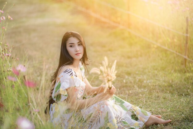 Portrait asian beautiful women sitting relax in the flower garden