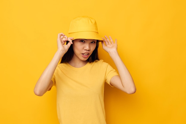 Photo portrait asian beautiful young woman in a yellow tshirt and hat posing emotions lifestyle unaltered