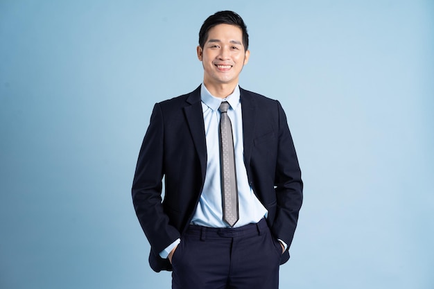 Portrait of asian businessman wearing suit on blue background