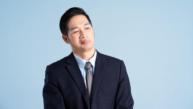 Portrait of asian businessman wearing suit on blue background