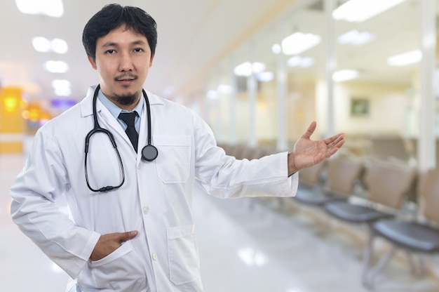 Portrait of Asian Doctor with the stethoscope equipment in welcoming gesture action onAbstract photo