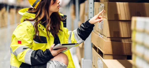 Portrait asian engineer woman shipping order detail on tablet check goods and supplies on shelves with goods background inventory in factory warehouselogistic industry and business export