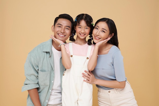 Portrait Asian family happy smiling together isolated on nude color background warm family concept