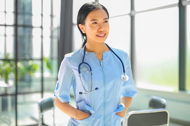 Portrait of asian female doctor holding hands and smiling