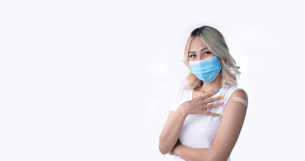 Portrait of Asian female wearing mask and holding four fingers after getting the fourth dose of vaccine on white background with copy space