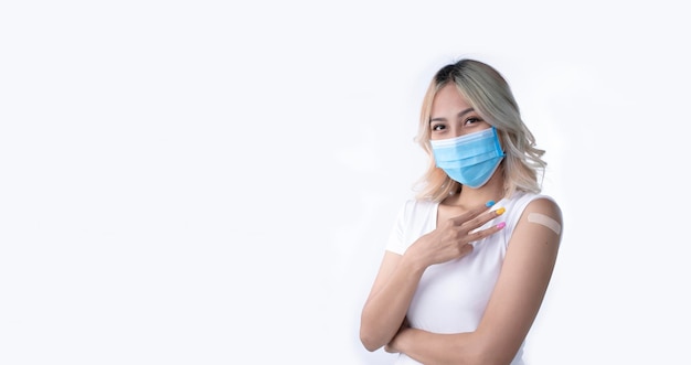 Portrait of Asian female wearing mask and holding three fingers for the third dose of vaccine on white background with copy space