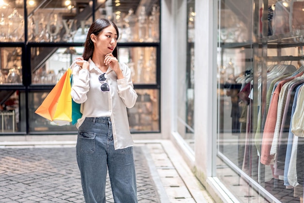 Portrait of Asian girl excited beautiful girl happy smiling with holding shopping bags relaxed expression Positive emotions shopping lifestyle concept