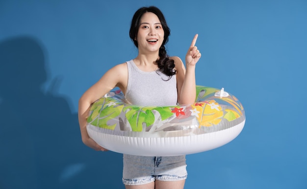 Portrait of asian girl posing on blue background traveling in summer