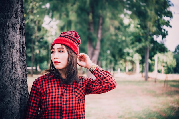 Portrait asian hipster girl on forest backgroundshe wear hat vintage styleCheerful girl fashion conceptthailand people