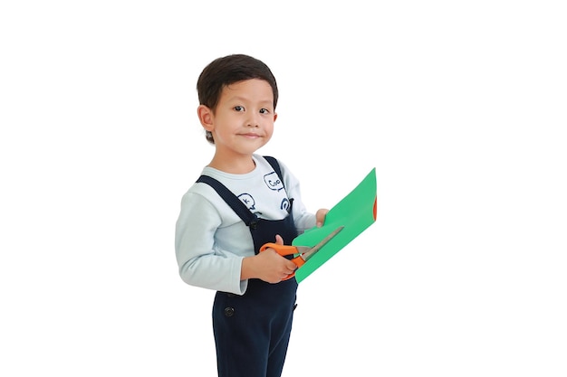 Portrait of Asian little boy craft work by scissors cut the color paper over white background