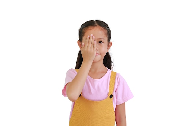 Portrait of Asian little girl child covering one eye with hand, confident smile on face isolated on white background.