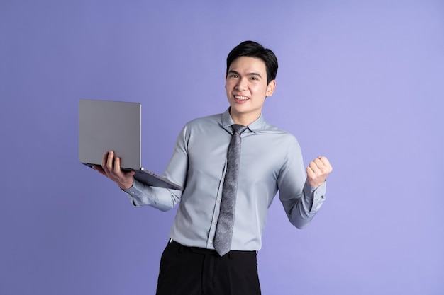 Portrait of Asian male businessman posing on purple background