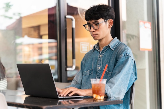 Portrait of Asian male student sitting at a coffee shop