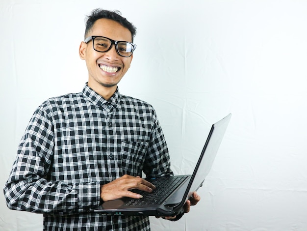 Portrait of an asian man holding a laptop with a smiling face expression advertising concept