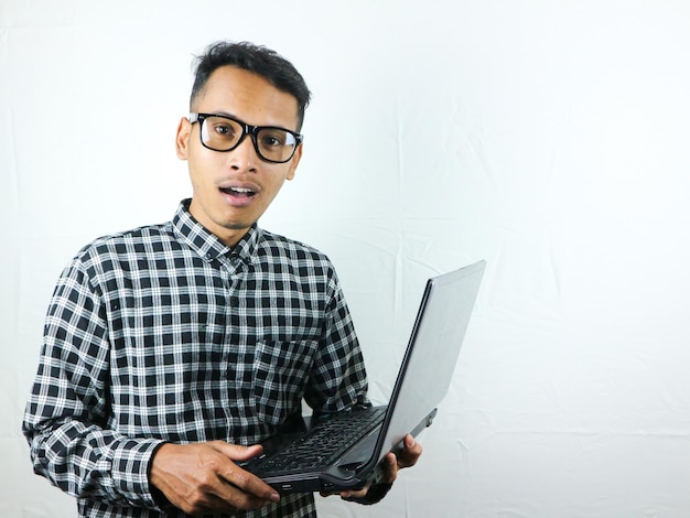 Portrait of asian man holding laptop with surprised expression advertising concept