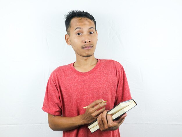 Portrait of an asian man holding pen and writing book isolated on white background