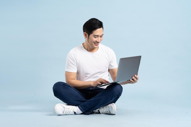 Portrait of asian man posing on blue background