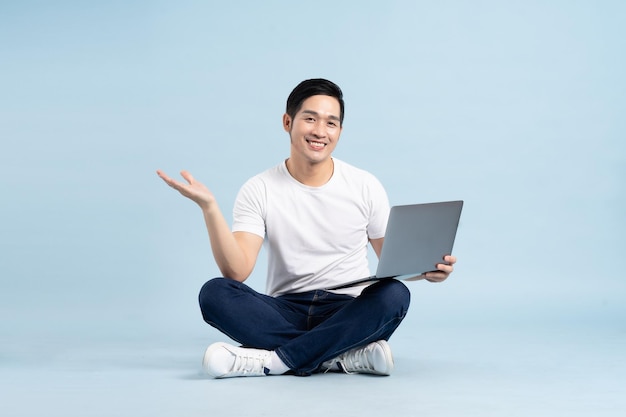 Portrait of asian man posing on blue background