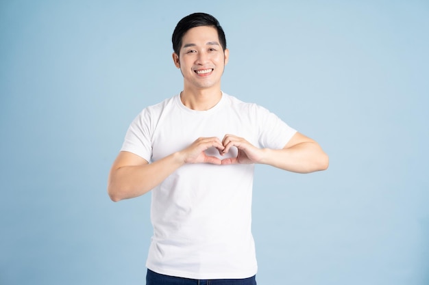 Portrait of asian man posing on blue background