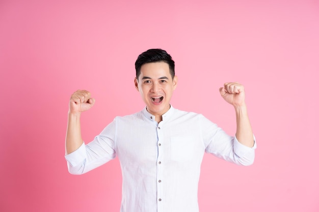 Portrait of asian man posing on pink background