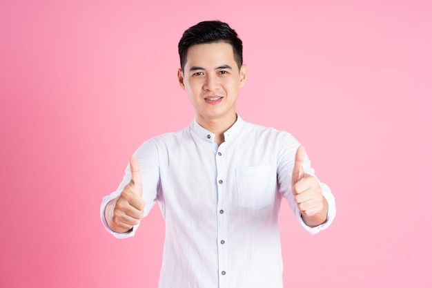 Portrait of asian man posing on pink background