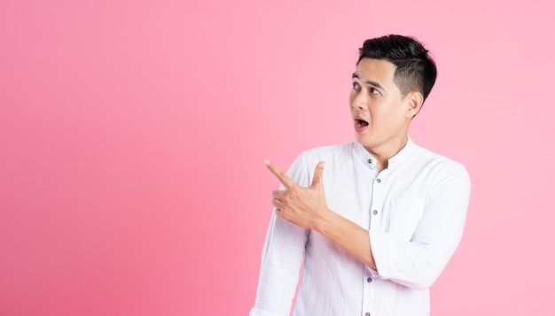 Portrait of asian man posing on pink background