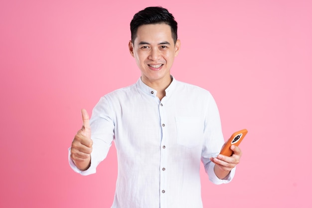 Portrait of asian man posing on pink background