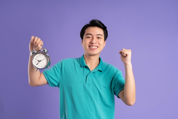 Portrait of asian man posing on purple background