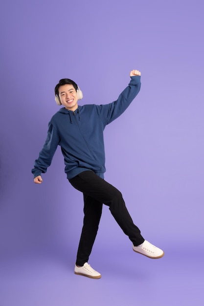 Portrait of asian man posing on purple background