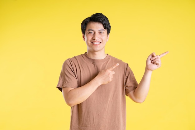 Portrait of asian man posing on yellow background