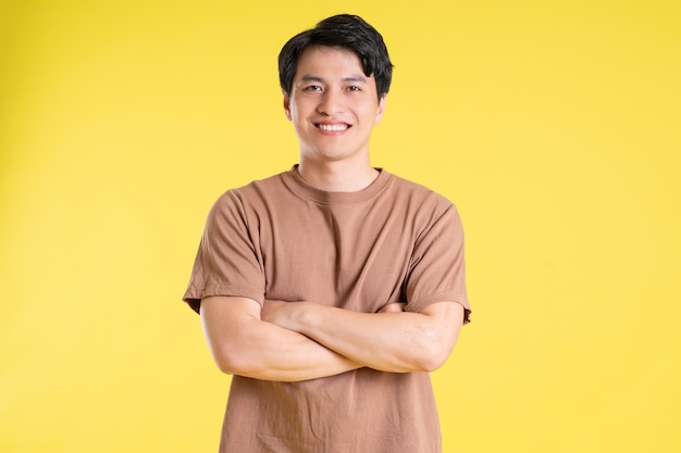 Portrait of asian man posing on yellow background