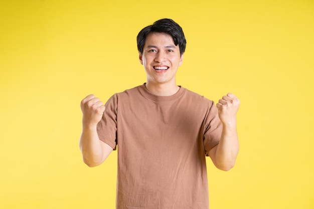 Portrait of asian man posing on yellow background