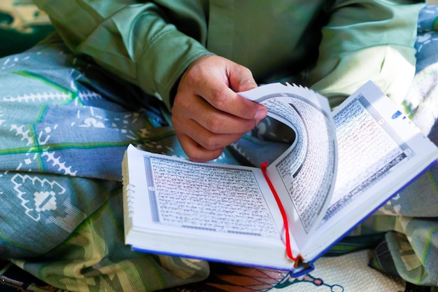 Photo portrait of an asian man reading the quran