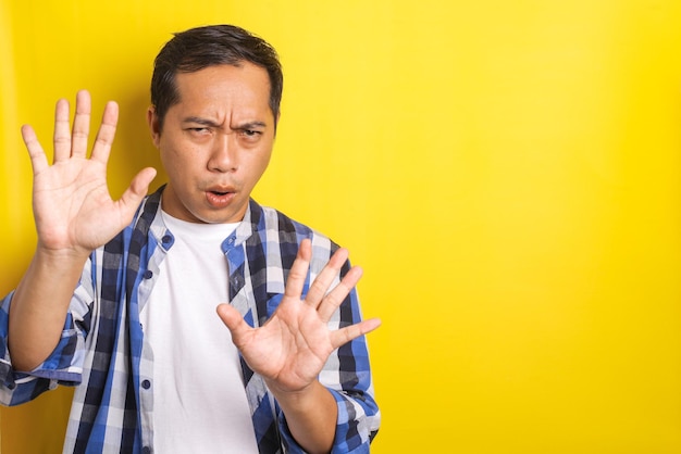 Portrait of asian man with admonishing finger gesture saying no disapproval sign with copy space