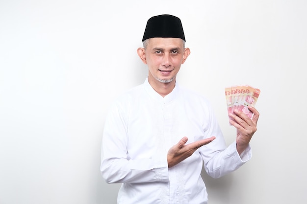 Portrait of Asian Moslem Man holding lots of money in hand, the concept of saving, investing