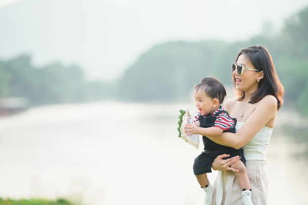 Portrait of a asian mother smiling with her 11 months old baby boy outdoor