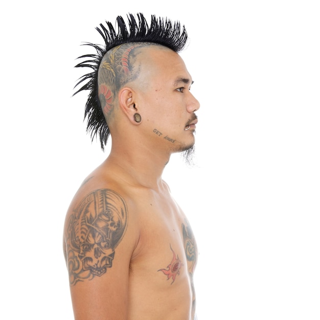 Photo portrait of asian punk guy with mohawk hair style, head tattoo, lip and ear piercing isolated on a white background