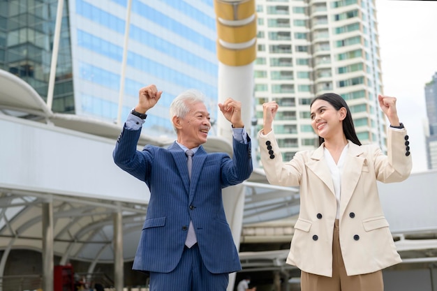 Portrait of Asian senior mature middle aged businessman and young businesswoman in modern city