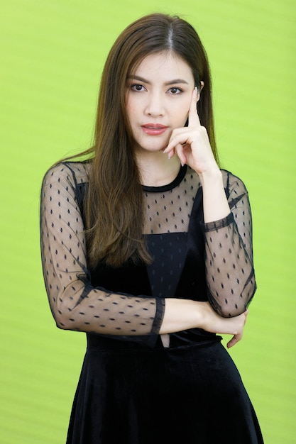 Portrait of Asian woman in black see through dress standking and pose with friendly positive smile face. Concept Beautiful and confident working woman.